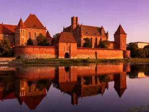 Widok na zabytkowe, kamienne podziemia Rynku z nastrojowym oświetleniem, podkreślającym historyczny charakter miejsca.